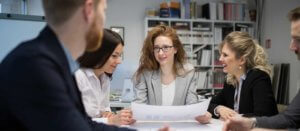 A professional woman talking her team through a project plan in an office environment